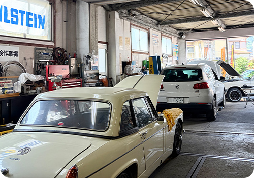 クラシックカーが並ぶYANSAN AutoServiceの整備工場の様子の写真